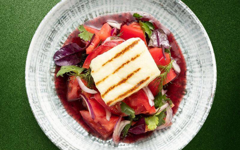 Салат с томатами, сыром халуми и соусом из алычи